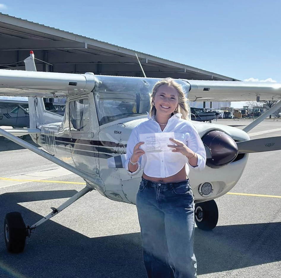 Aerotech student smiling next to a training aircraft
