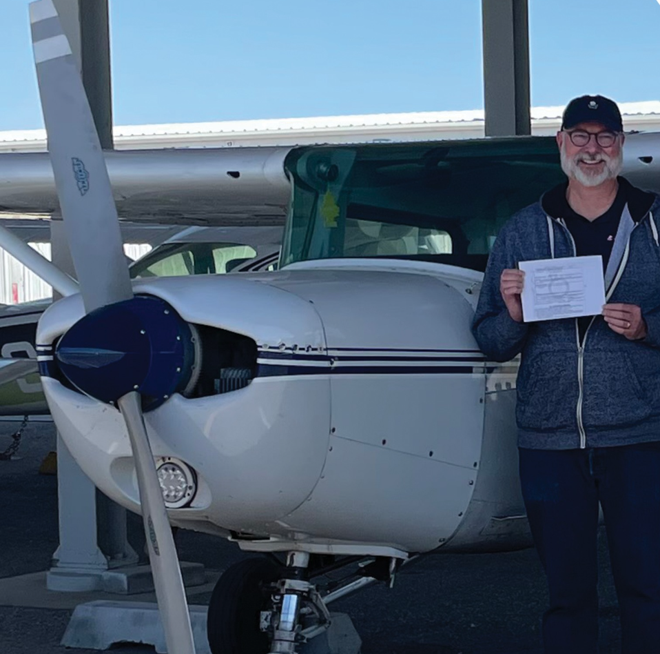 Aerotech pilot next to a blue and white aircraft